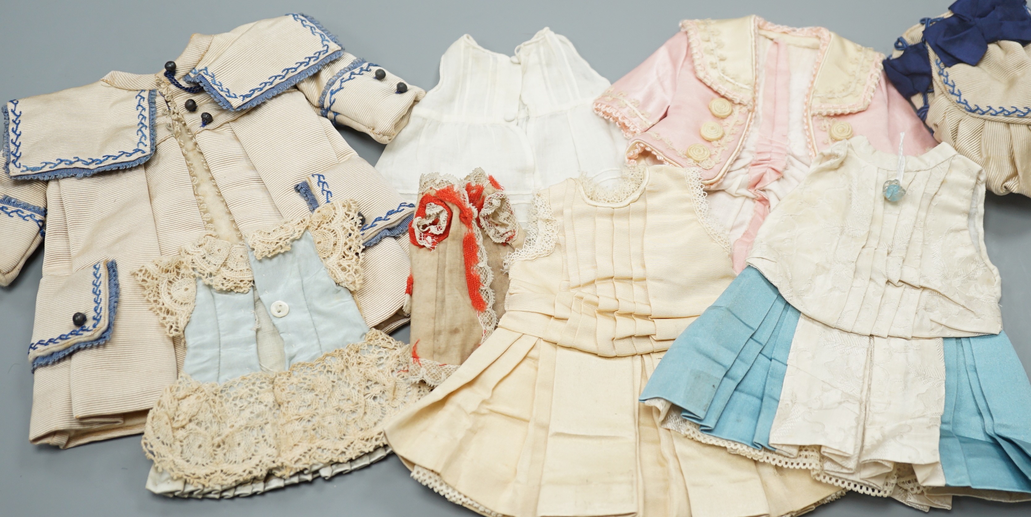 Four French style dolls dresses, average 22cm, a French silk coat and bonnet, 18cm and a small French dress and petticoat silk and lace, 12cm